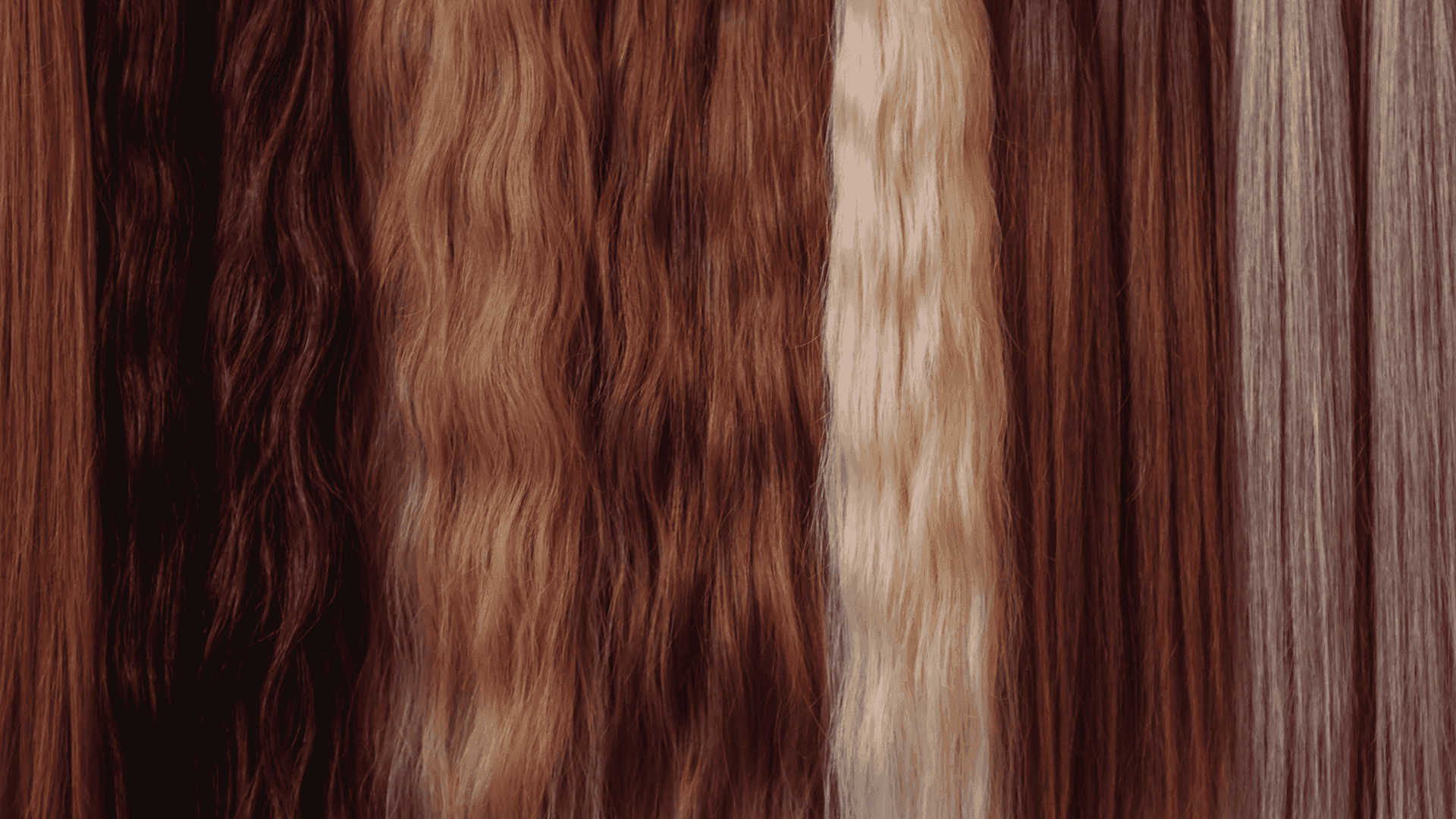 Various shades of natural hair extensions displayed in vertical rows.